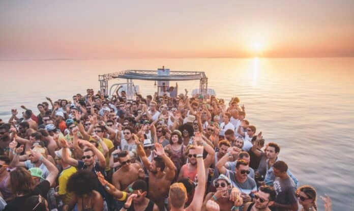 Festival crowd aboard boat at sunset