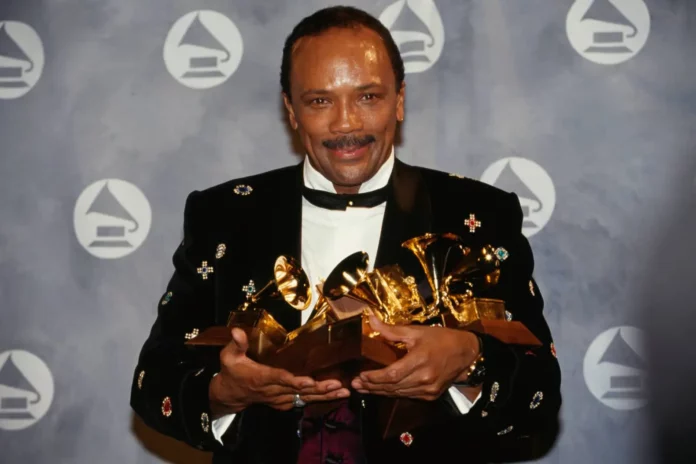 Quincy Jones holding Grammy awards