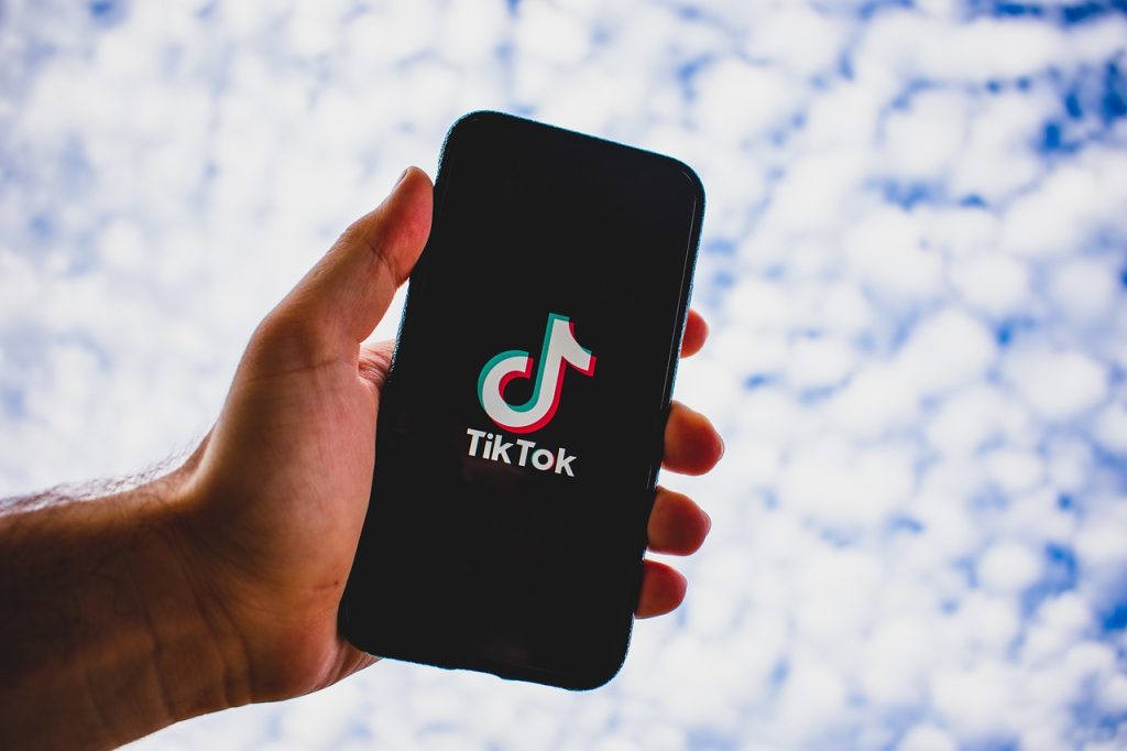 TikTok on phone against sky backdrop