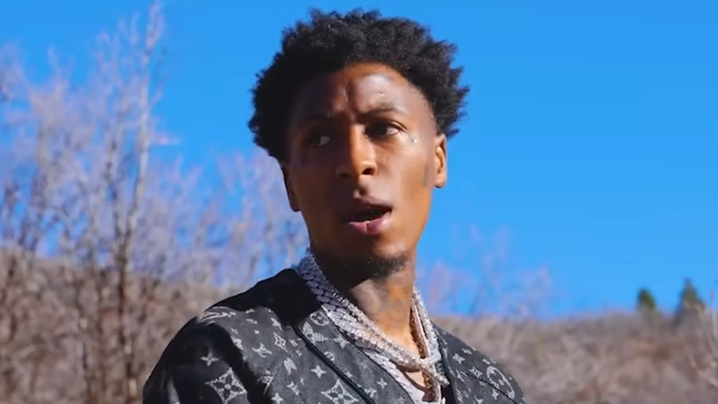 NBA YoungBoy outdoors against blue sky