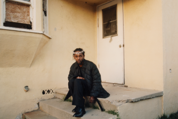 Kendrick Lamar seated on porch