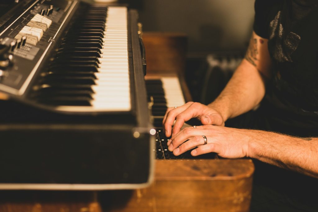 Musician playing keyboard in dim lighting