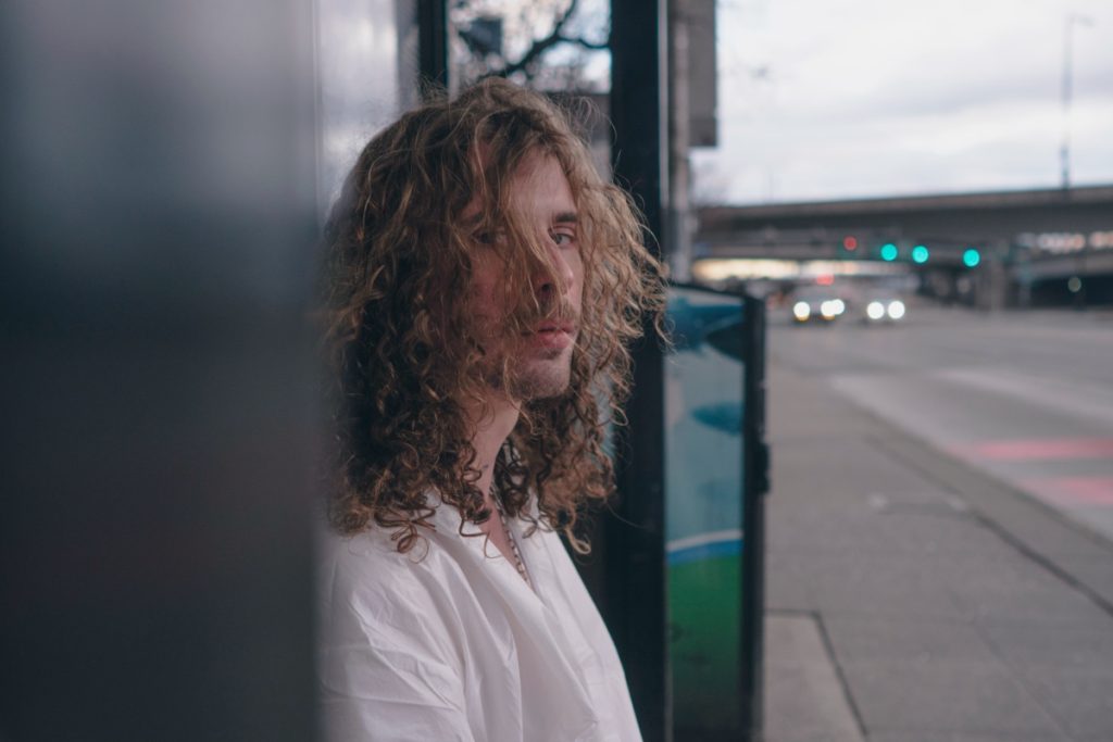 Man with curly hair in sunlight