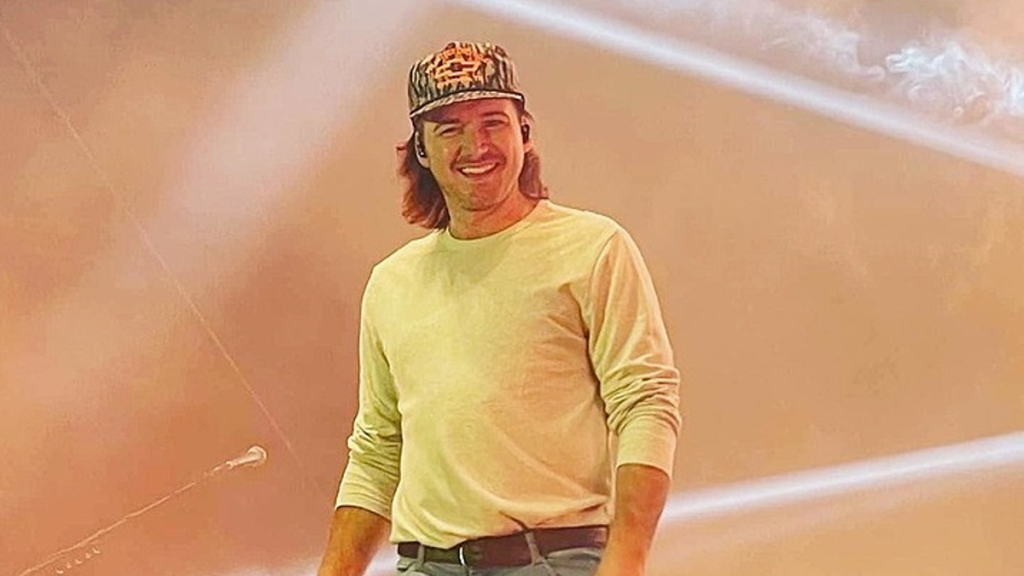 Morgan Wallen smiling in black hat