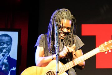 Tracy Chapman performing with acoustic guitar