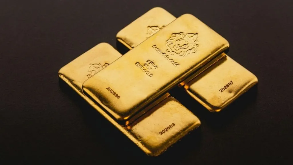 Gold bars stacked on reflective surface