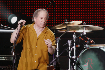 Paul Simon performing on concert stage