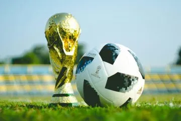 Soccer trophy and ball on grass